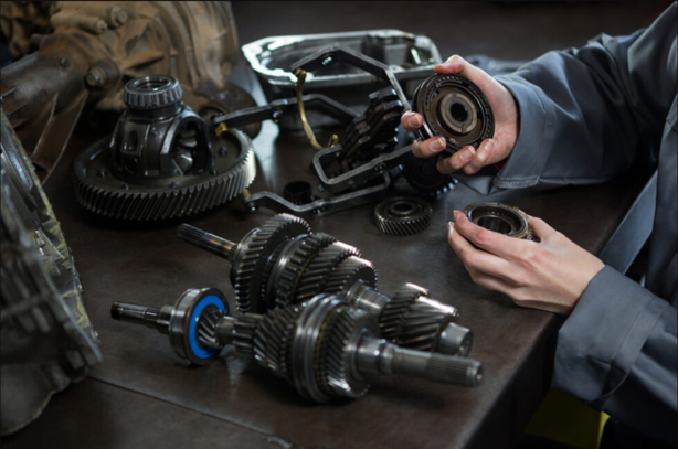 Female Mechanic Holding Spare Parts Of Car